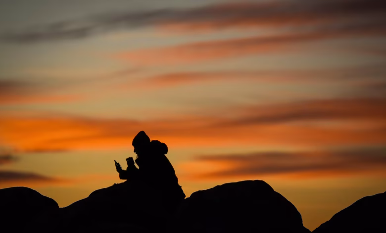 A woman uses her phone during sunset at Sunset Beach in Vancouver in January 2025. B.C. is one of several provinces to stop changing its clocks twice a year. (Darryl Dyck/The Canadian Press)