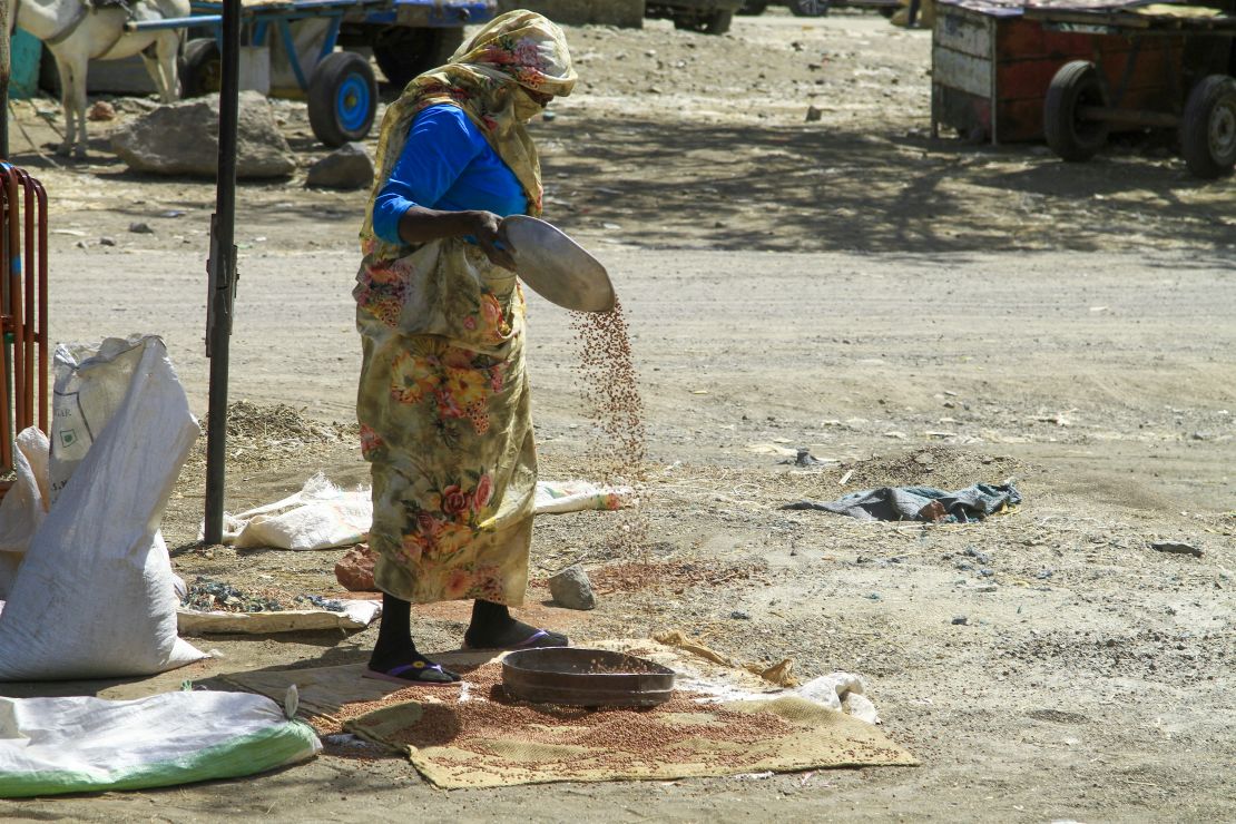A woman sorts grains at a market in Gedaref, eastern Sudan, on February 22, 2024. Nearly a year into a war that has sent Sudan to the verge of collapse, the vast majority of its people are going hungry, the UN's World Food Programme says.