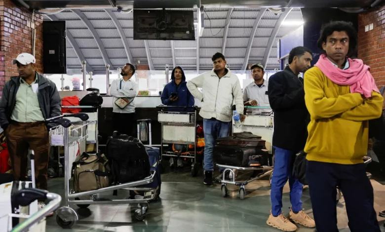 Travelers check digital flight information boards showing widespread cancellations at an international airport as global airlines suspend schedules due to airspace closures linked to the U.S.–Iran conflict.